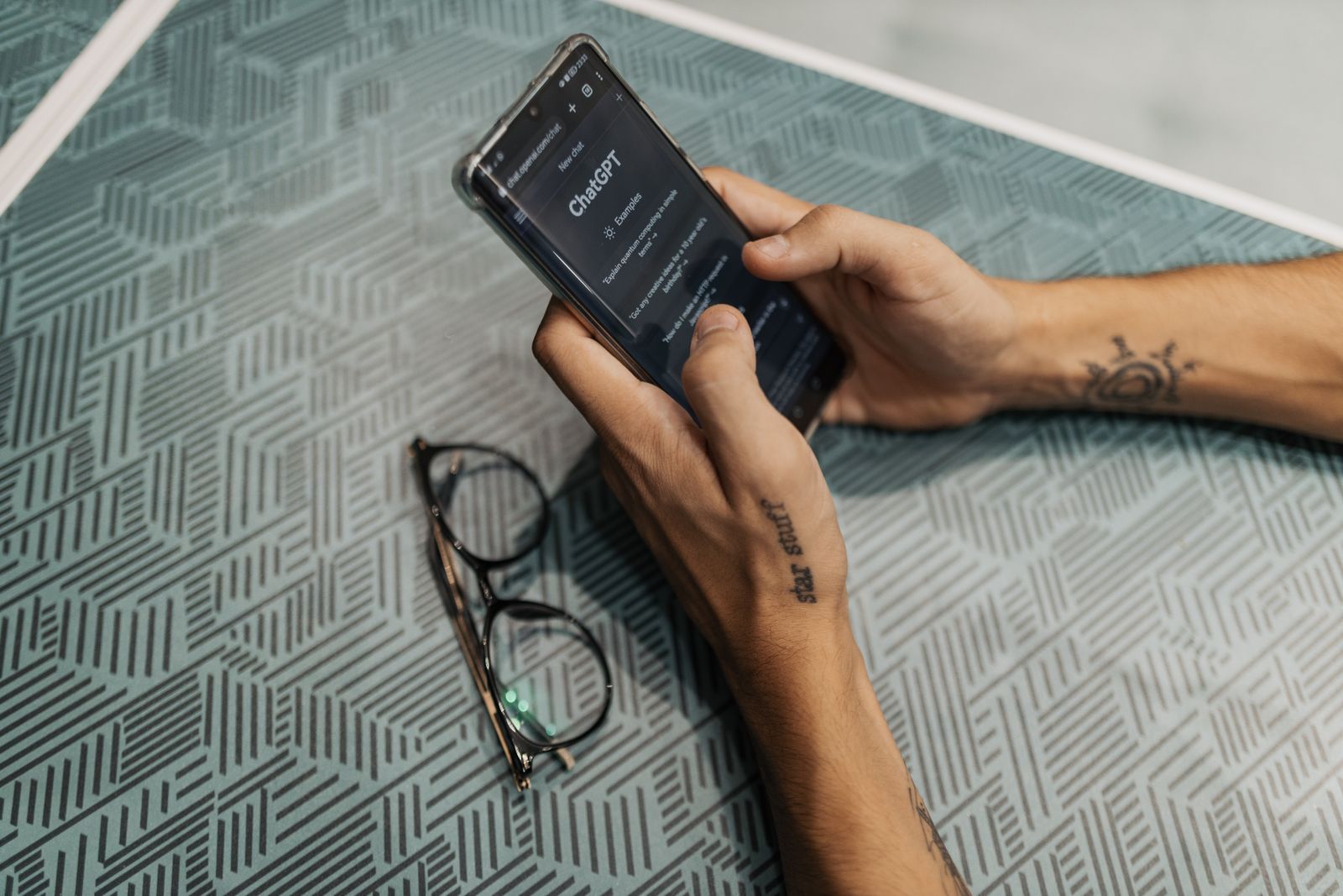 Mano che tiene uno smartphone con app ChatGPT aperta, ricerca tramite AI